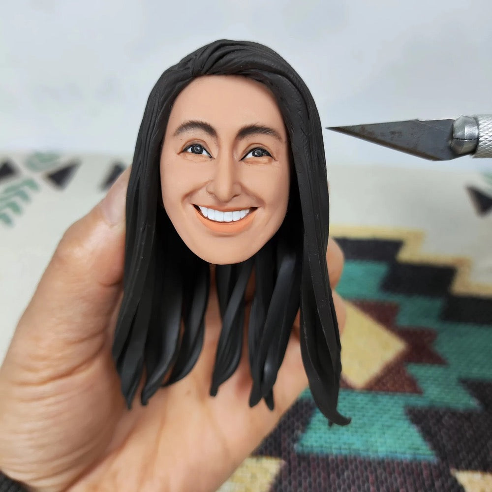 Custom female doctor bobblehead with long hair, being hand-painted for personalization.