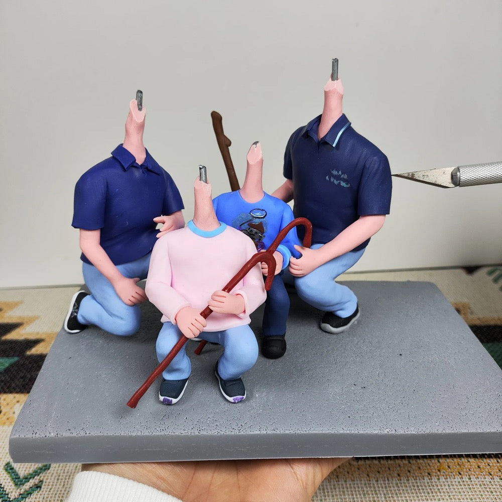 Figurines of people in a staged scene with tools on a gray surface.
