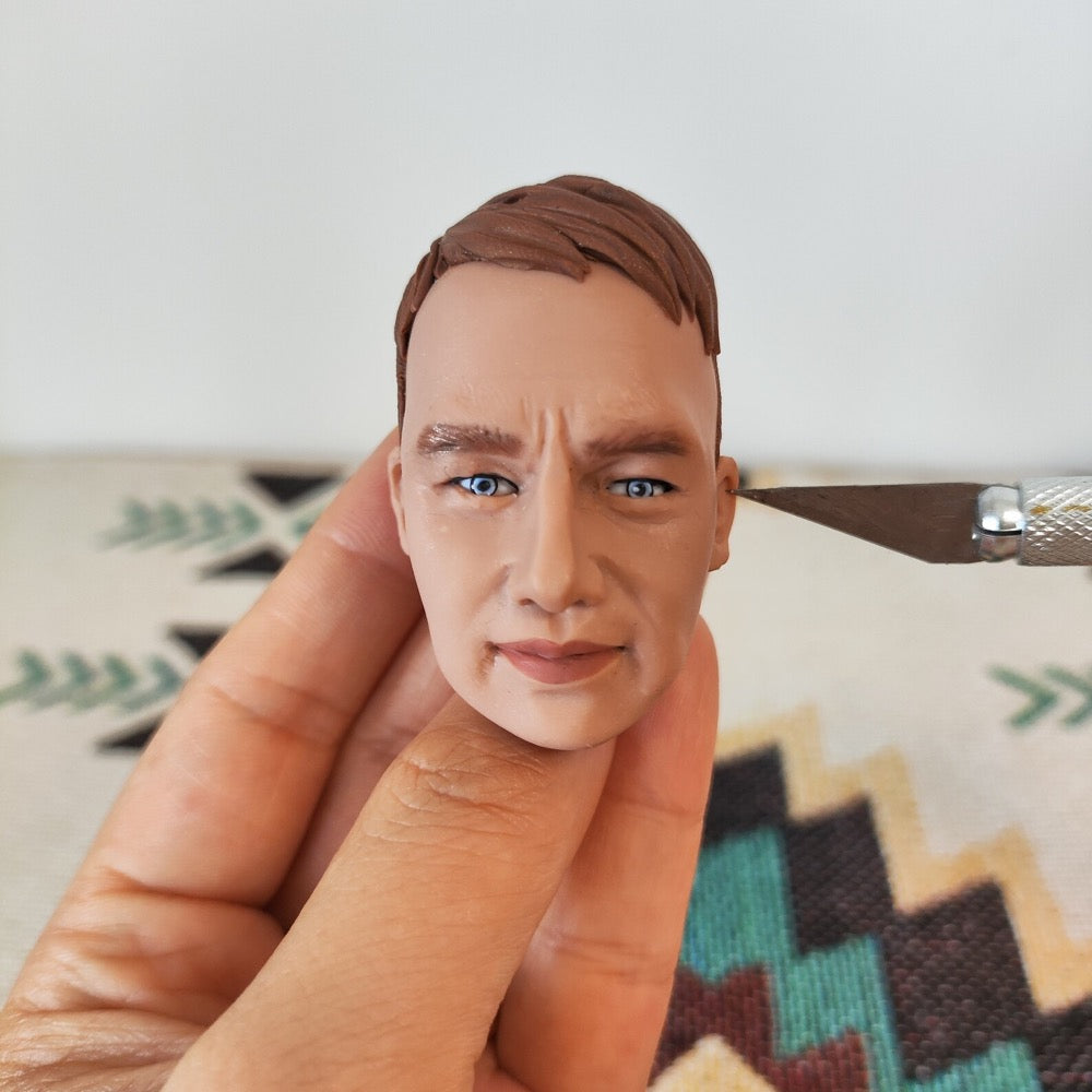 Handmade custom bobblehead face sculpting process from a customer photo