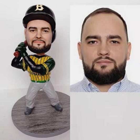 Bobblehead of a baseball player in a green and yellow uniform next to a real person with a beard.