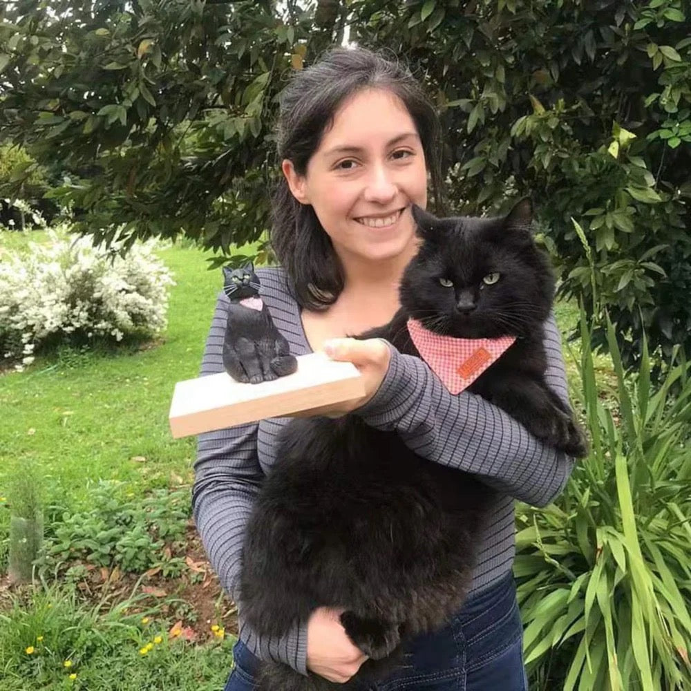 Woman holding a black cat with a pink bandana outdoors